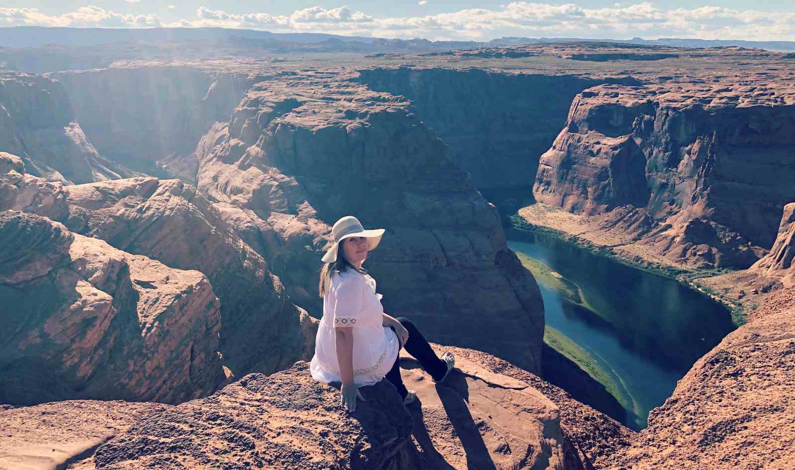 Blogger Paula sitting on the edge of Horseshoe Bend in Arizona