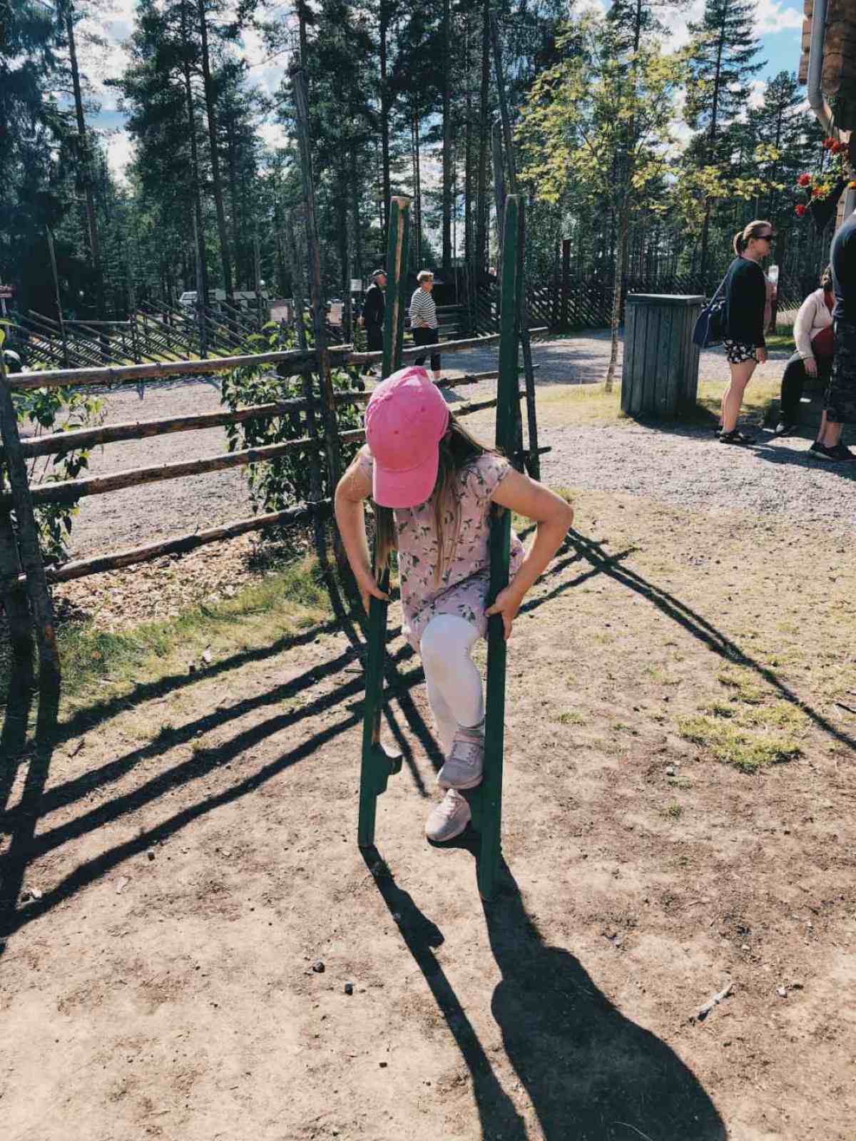Meidän tytär kokeilemassa puujalkoja Ähtärin eläinpuistossa