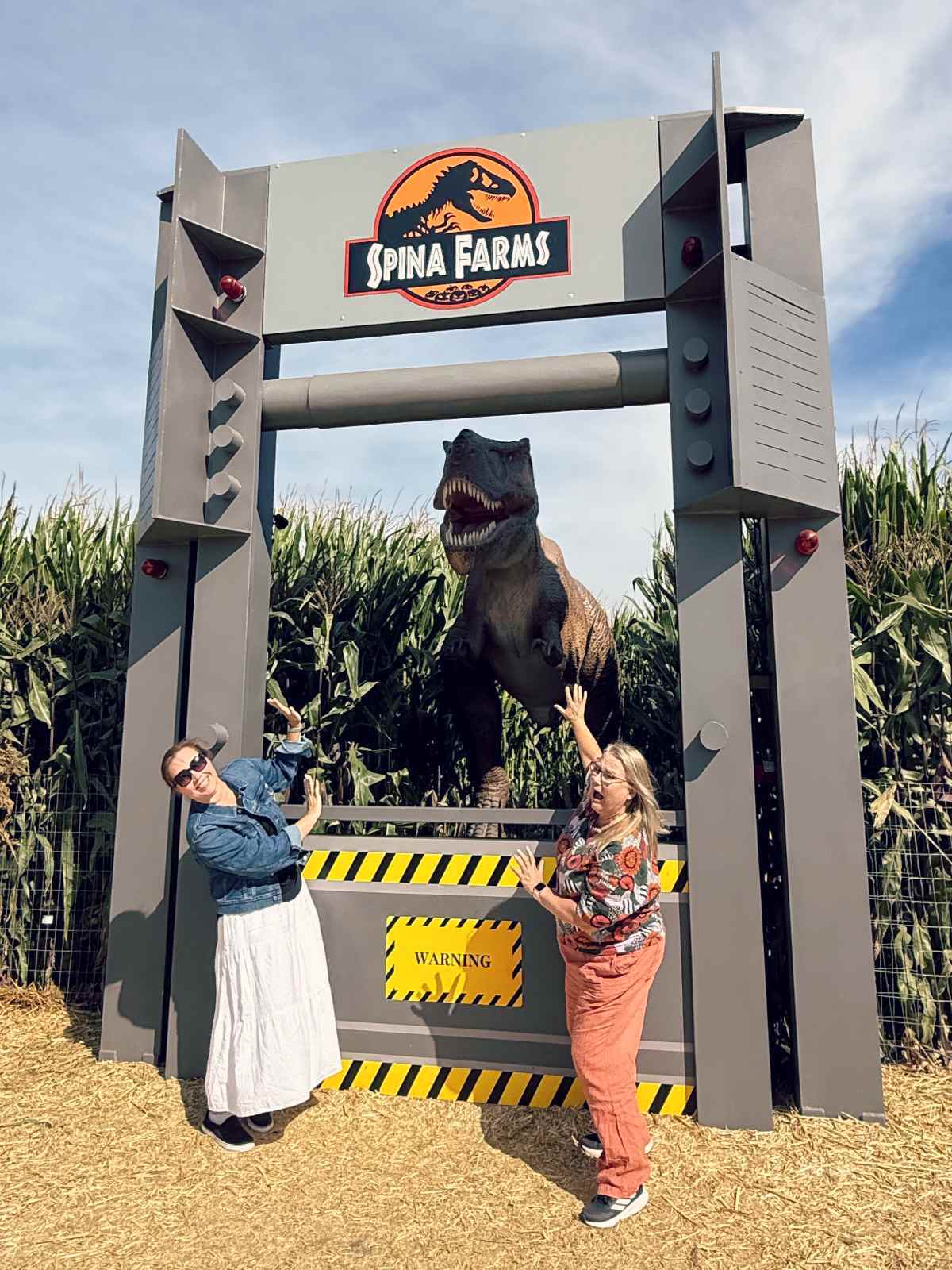 Blogger Paula and a friend scared of dinosaur at Spina Farms Pumpkin Patch in Morgan Hill