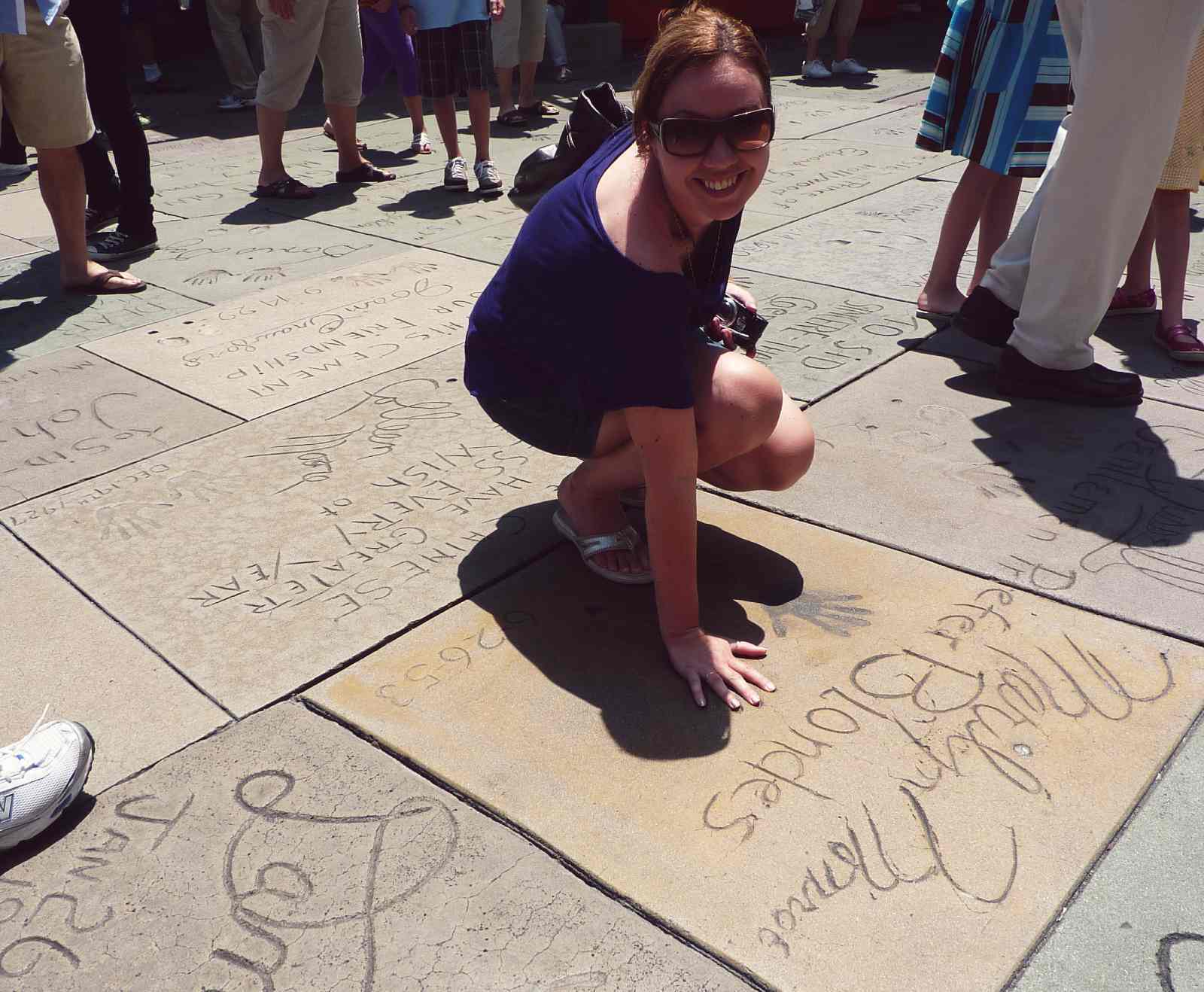 Blogger Paula touching Marilyn Monroe handprints in Hollywood by Chinese Theatre