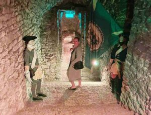 Blogger Paula walking down to the dark Bastion Tunnels underground of Tallinn, Estonia