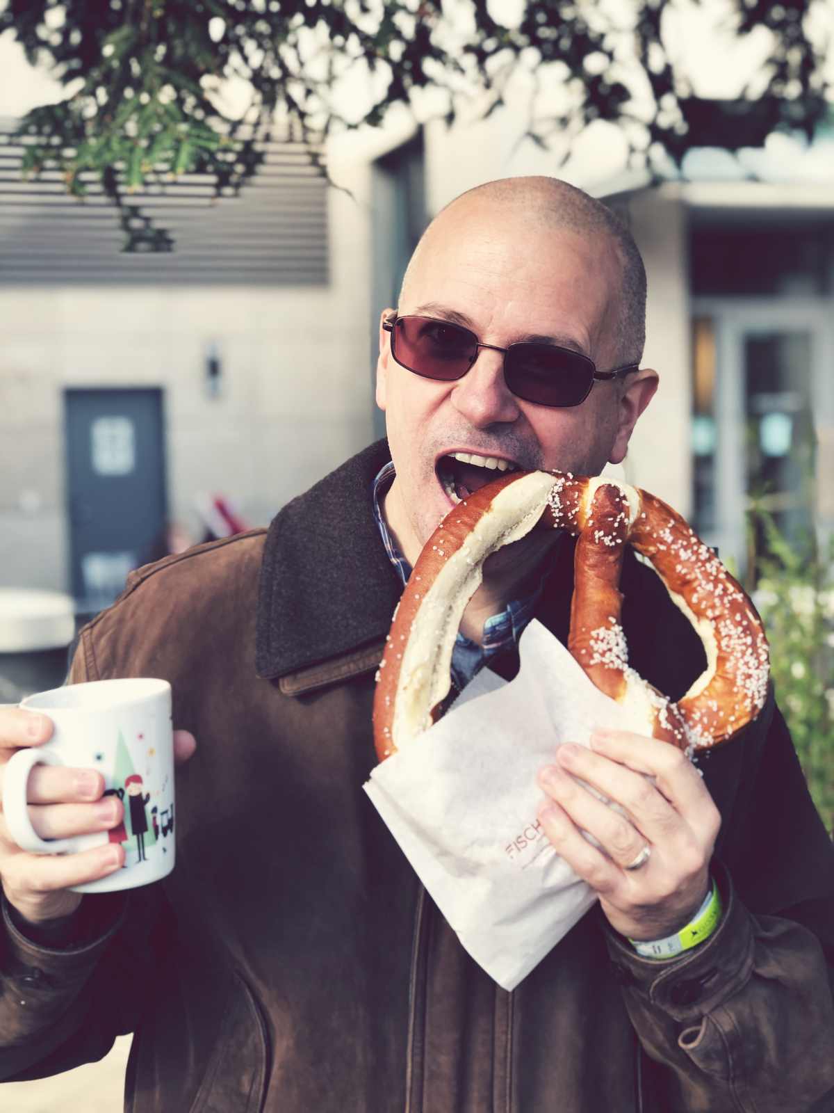My husband eating a giant pretzel at German Holiday Market in Mountain View, California