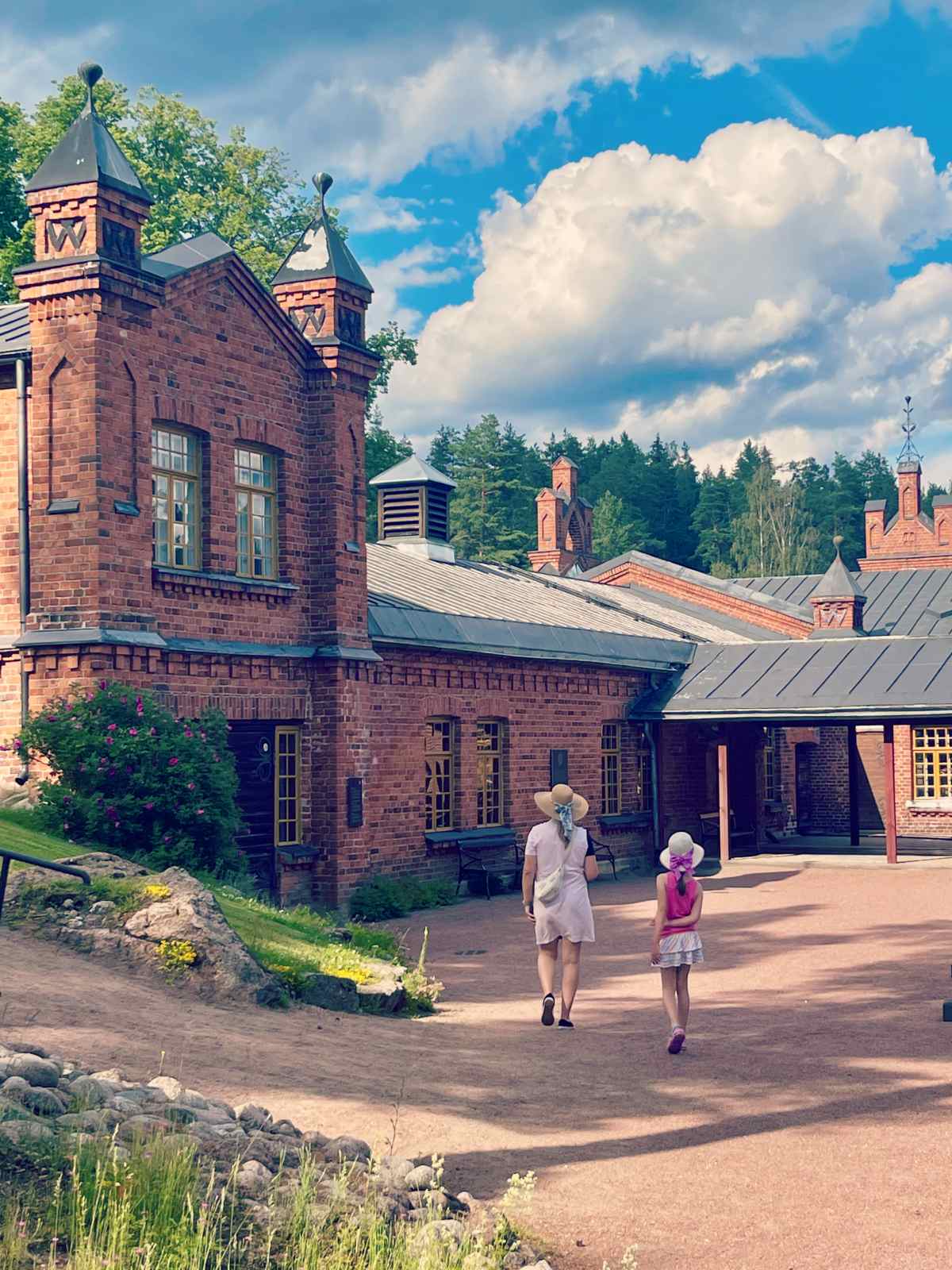 Bloggaaja Paula kävelemässä Verlan tehtaan edessä lapsen kanssa