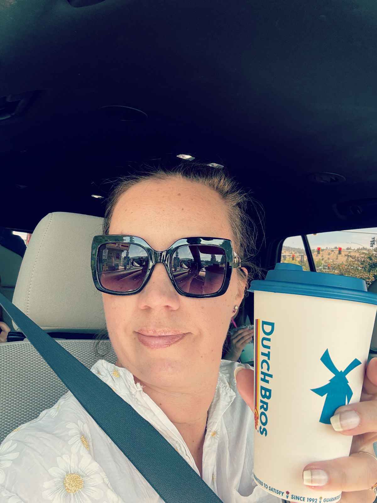 Bloggaaja Paula iloisena Dutch Bros kahvimukin kanssa Kaliforniassa