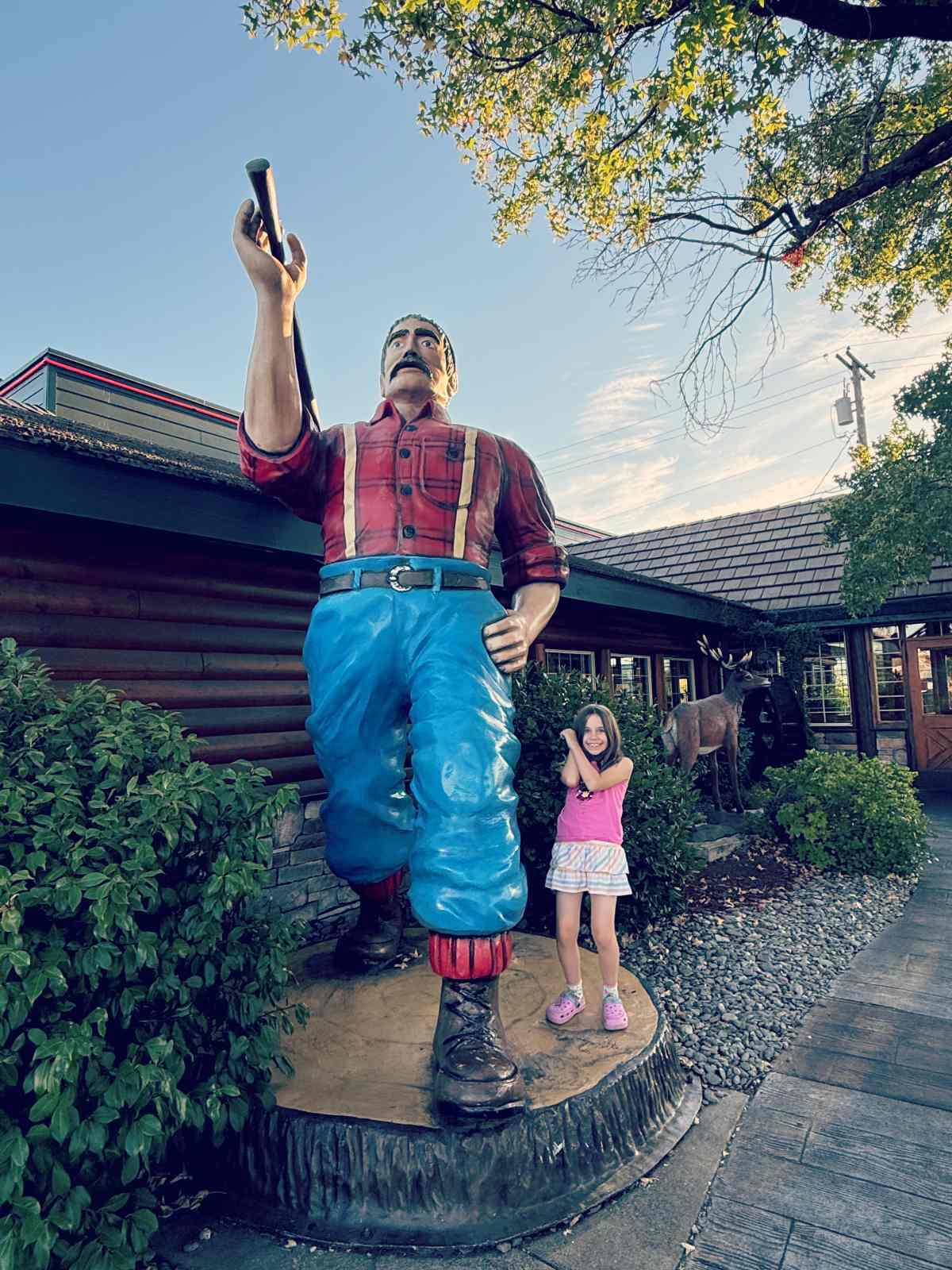 Meidän pienin neiti Reddingin kaupungissa, Kaliforniassa Lumberjack ravintolan pihalla ison patsaan vieressä 