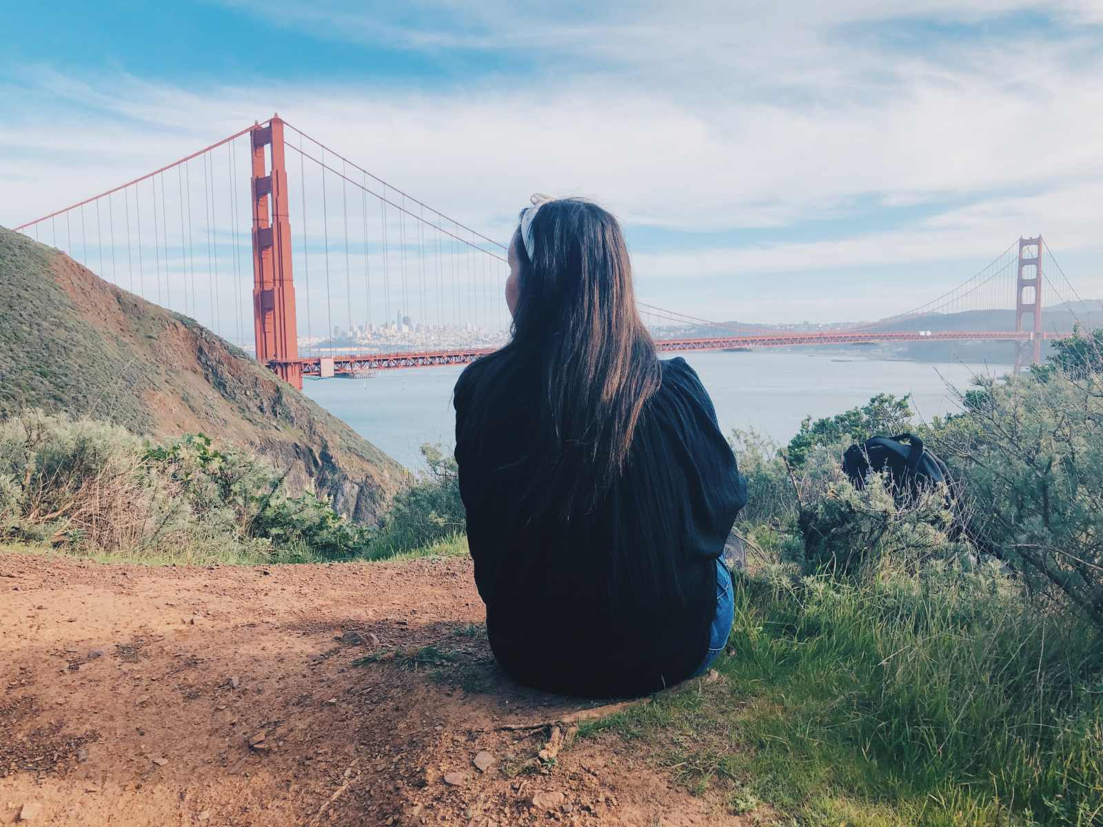 Blogger Paula sitting in front of San Francisco's Golden Gate Bridge