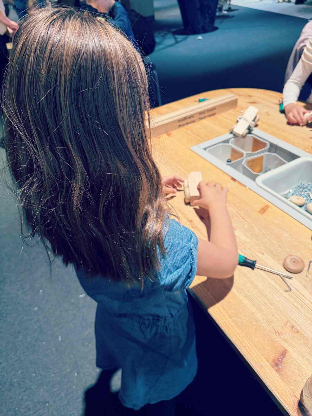 Meidän nuorin neiti kokoamassa puista leikkiautoa Tiedekeksus Heurekassa