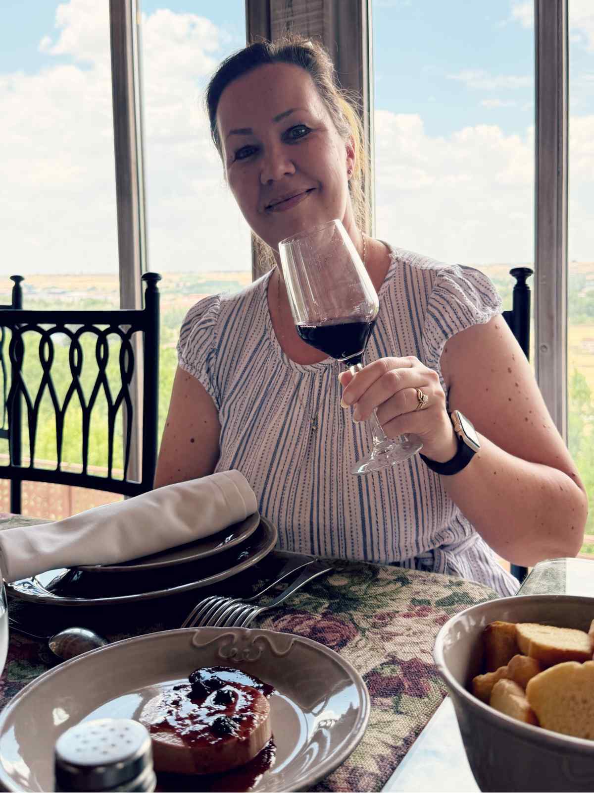 Bloggaaja Paula kilistelemässä viinillä perinneruokien keskellä Asador de Eufrasio -ravintolassa Espanjan Lermassa.
